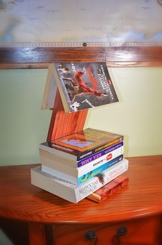 a stack of books sitting on top of a wooden table next to a lamp shade