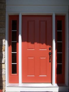 an orange front door with two sidelights