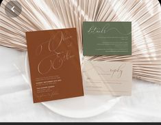 the wedding stationery is set on top of a white plate with gold foiling