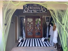 two mannequins dressed in white and black are standing outside the entrance to a boutique