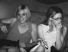 three women sitting on a couch with remotes in their hands