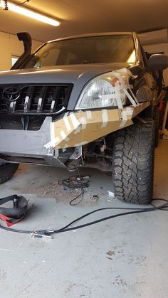 the front end of a truck being worked on in a garage with tools around it