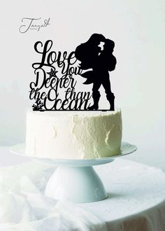 a cake topper that says love is in the air and a silhouette of a kissing couple