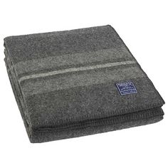 a gray blanket folded on top of a white surface with a blue label in the middle