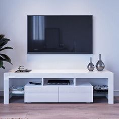 a flat screen tv mounted to the side of a white entertainment center in a living room