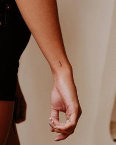 a woman's hand with a small tattoo on it