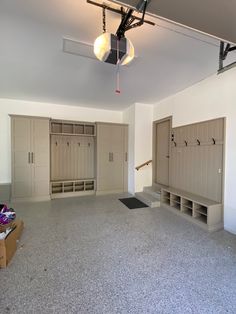 an empty room with several lockers and shelves in the center, including two benches