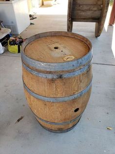 a wooden barrel sitting on top of a cement floor