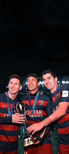 three men in striped shirts holding a trophy