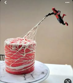 a spiderman cake is being dunked with white icing