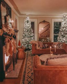 a living room filled with furniture and christmas trees in front of a fireplace covered in lights