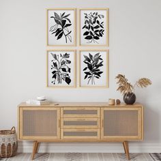 three black and white prints on the wall above a sideboard