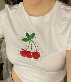 a woman wearing a white shirt with two cherries on it