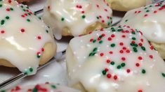 there are many cookies with white icing and sprinkles on the tray