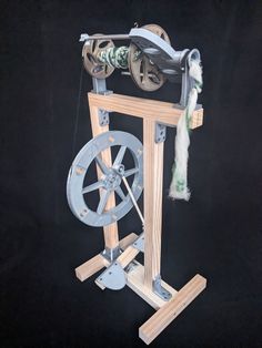 an old fashioned spinning machine with wheels and spools on it's sides