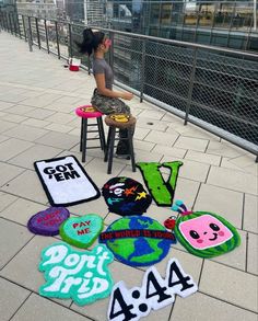 a woman sitting on top of a stool next to various rugs