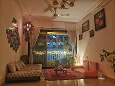 a living room filled with furniture next to a large window covered in pictures and lights