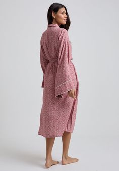 The charming Corina robe is cut from our inimitable cotton and adorned with an interesting pink Ditsy floral print. This oversized kimono-inspired robe boasts fluted sleeves and a detachable belt, creating a flattering silhouette. Contrast piping on the cuff and neck, complete this effortlessly feminine piece.  Cool machine wash only. Wash inside out and with similar colours 100% Cotton Sourced India  Cool machine wash only. Wash inside out and with similar colours Feminine Floral Print Robe For Loungewear, Pink Cotton Sleep Robe, Spring Cotton Robe With Floral Print, Pink Floral Print Home Robe, Pink Floral Print Robe For Home, Cotton Floral Print Robe For Daywear, Pink Feminine Robe For Sleepover, Feminine Pink Robe For Sleepover, Pink Cotton Home Robe