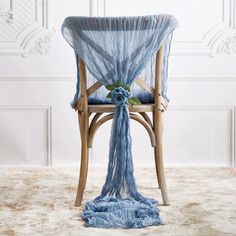 a chair with a blue fabric draped over it and a flower on the backrest