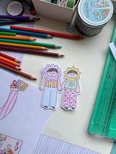 the paper dolls are next to colored pencils