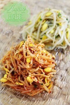 some food is sitting on top of a wooden table next to another plate with noodles and vegetables