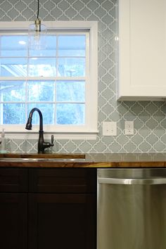 a kitchen with a sink, dishwasher and window in the backround