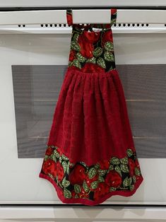 a red dress hanging from the side of an oven