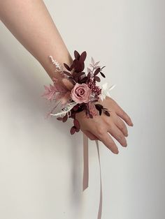 a woman's hand holding a wrist corsage