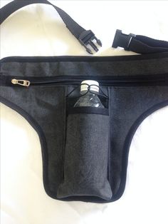 a black fanny bag with a bottle in it on a white surface, the bottom half is empty