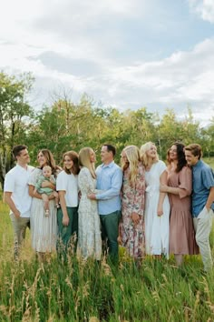 a group of people standing together in the grass