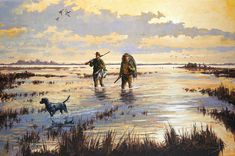 two men are walking in the water with their dogs