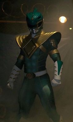 a man dressed in green and gold standing next to a white light with his hands on his hips