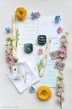 the wedding stationery is laid out with flowers, candles, and other things to put on it