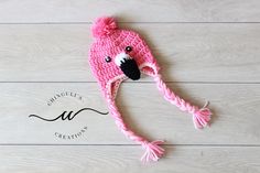 a pink crocheted hat with a black nose