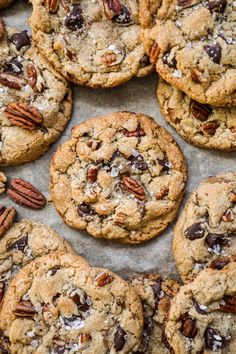 chocolate chip cookies with pecans and pecans in the middle on a baking sheet