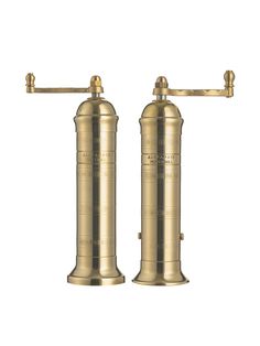 two brass - plated pepper grinds are shown against a white background