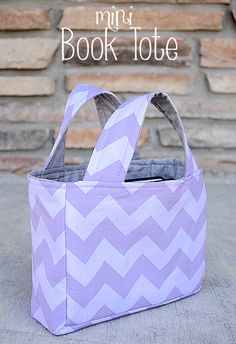 a purple and white bag sitting on top of a sidewalk