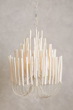 a white chandelier hanging from a chain with sticks sticking out of the bottom