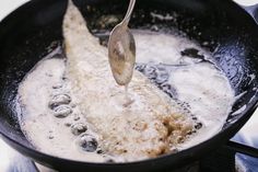 a frying pan with some food in it and a spoon sticking out of it