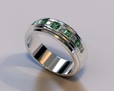 a wedding ring with green and white stones on the inside, set in 18k white gold