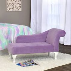 a purple chair sitting on top of a white rug next to a bed in a bedroom