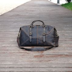 Crafted from the finest, vintage-look leather, this highly functional duffle bag is designed to tote everything from clothing to a laptop. It is large enough for storing a laptop (up to 17''), clothing, shoes. And it has other interior pockets for storing things like your charger, and mobile phone.It has a removable and adjustable shoulder strap. It is fully lined with robust cotton canvas. and It is extendable at boths sides.This bag comes with a leather luggage tag. Use professional leather ca Leather Duffle Bag With Waxed Finish For Business, Classic Business Duffle Bag With Waxed Finish, Classic Waxed Finish Duffle Bag For Business, Classic Everyday Duffle Bag With Waxed Finish, Oiled Leather Travel Bag With Luggage Sleeve, Travel Bags With Luggage Sleeve In Oiled Leather, Vintage Travel Bag For Business With Leather Lining, Leather Tote Duffle Bag With Waxed Finish, Vintage Leather Travel Bag For Business Trips