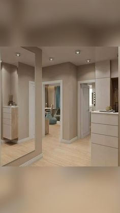 an empty living room and kitchen with large mirrors on the wall, in neutral colors