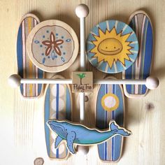 three wooden magnets with different designs on them and one has a sun, whale, and starfish