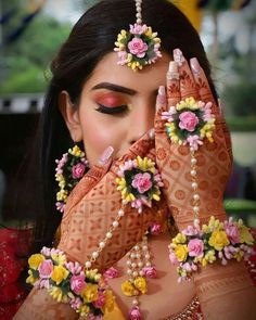 a woman with her hands covering her face and holding flowers in front of her face