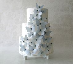 a white and blue wedding cake with butterflies on it