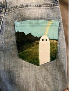 someone is holding out their pocket to show the ghost in the field with a rainbow