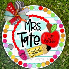 a sign that says mrs tate in english and has an apple on it with the words,