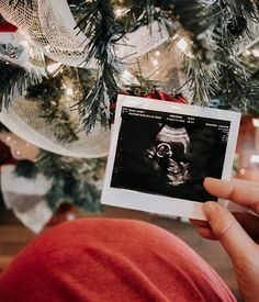 a person holding up an x - ray image in front of a christmas tree