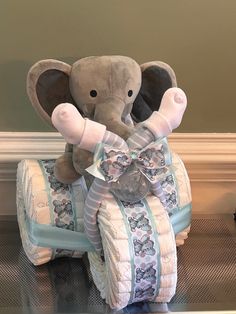 an elephant stuffed animal sitting on top of a baby crib with its trunk in the air